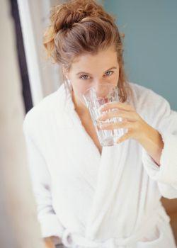 Woman Drinking Water Before Getting in Sauna